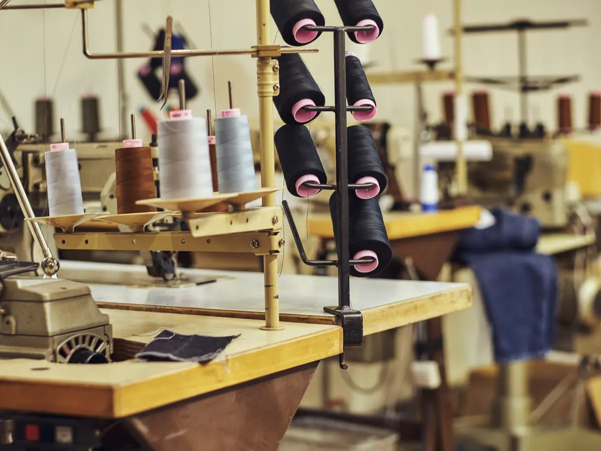 Thread cones and sewing machines on the AZLABIN production floor